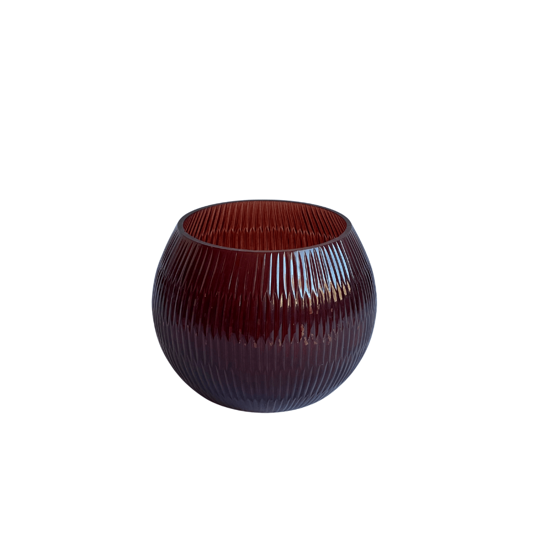Photophore en verre bordeaux à surface cannelée et forme arrondie. Idéal pour accueillir une bougie perlée ou servir de vase décoratif. Parfait comme idée cadeau élégante.