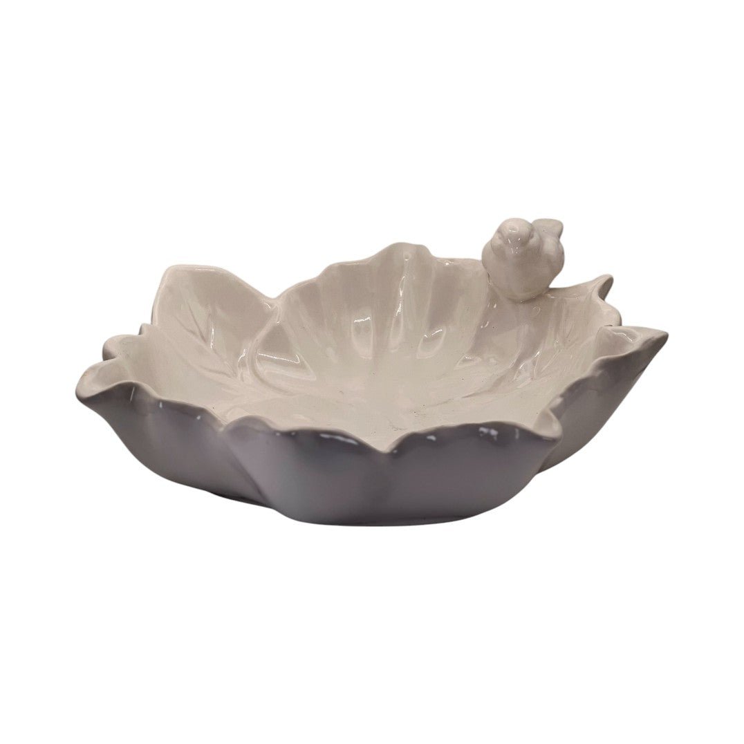 Vide-poche décoratif en forme de feuille avec un petit oiseau en céramique. Ton blanc et gris doux. Parfait pour ranger vos bijoux, clés ou accessoires. Élégant et naturel.