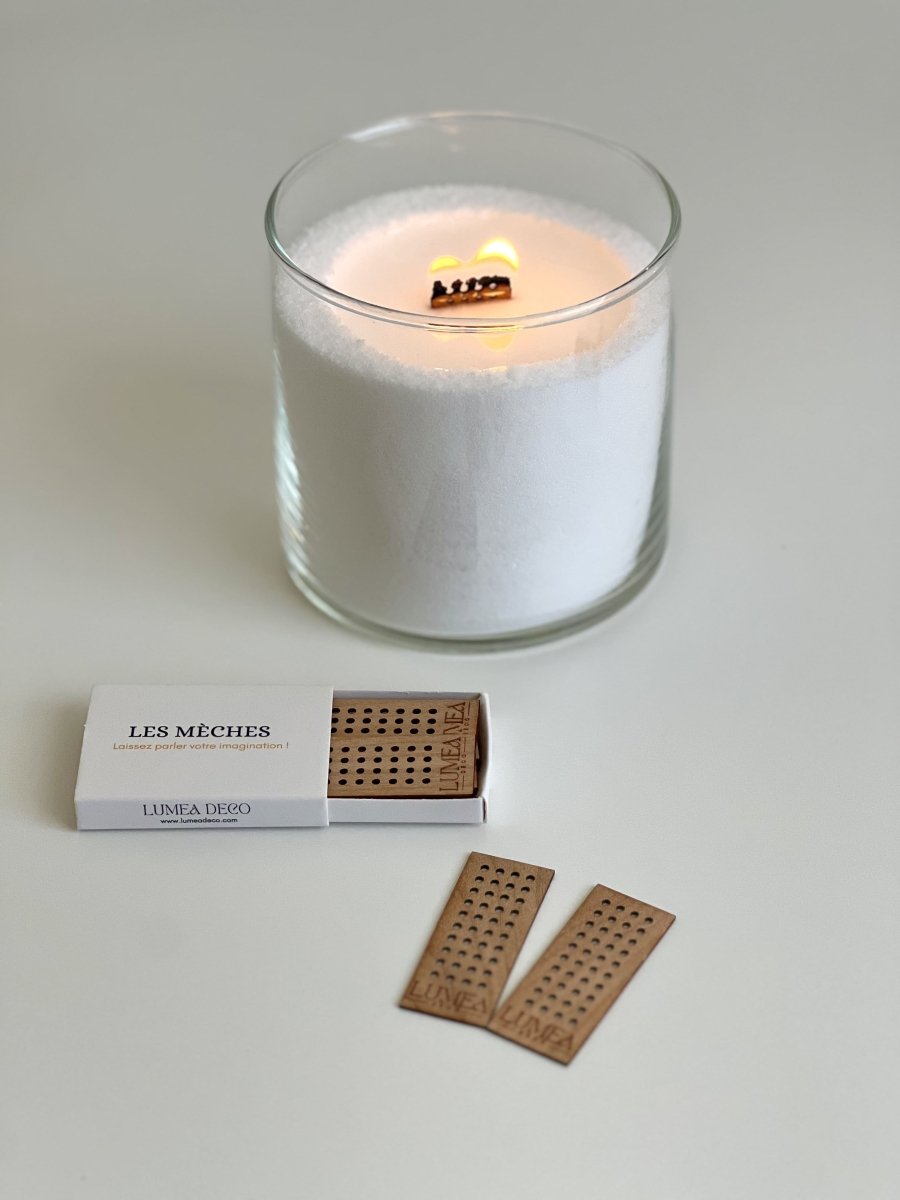 Bougie perlée blanche Lumea allumée dans un contenant en verre, accompagnée de mèches en bois et d’une boîte d’accessoires – concept rechargeable, naturel et personnalisable.