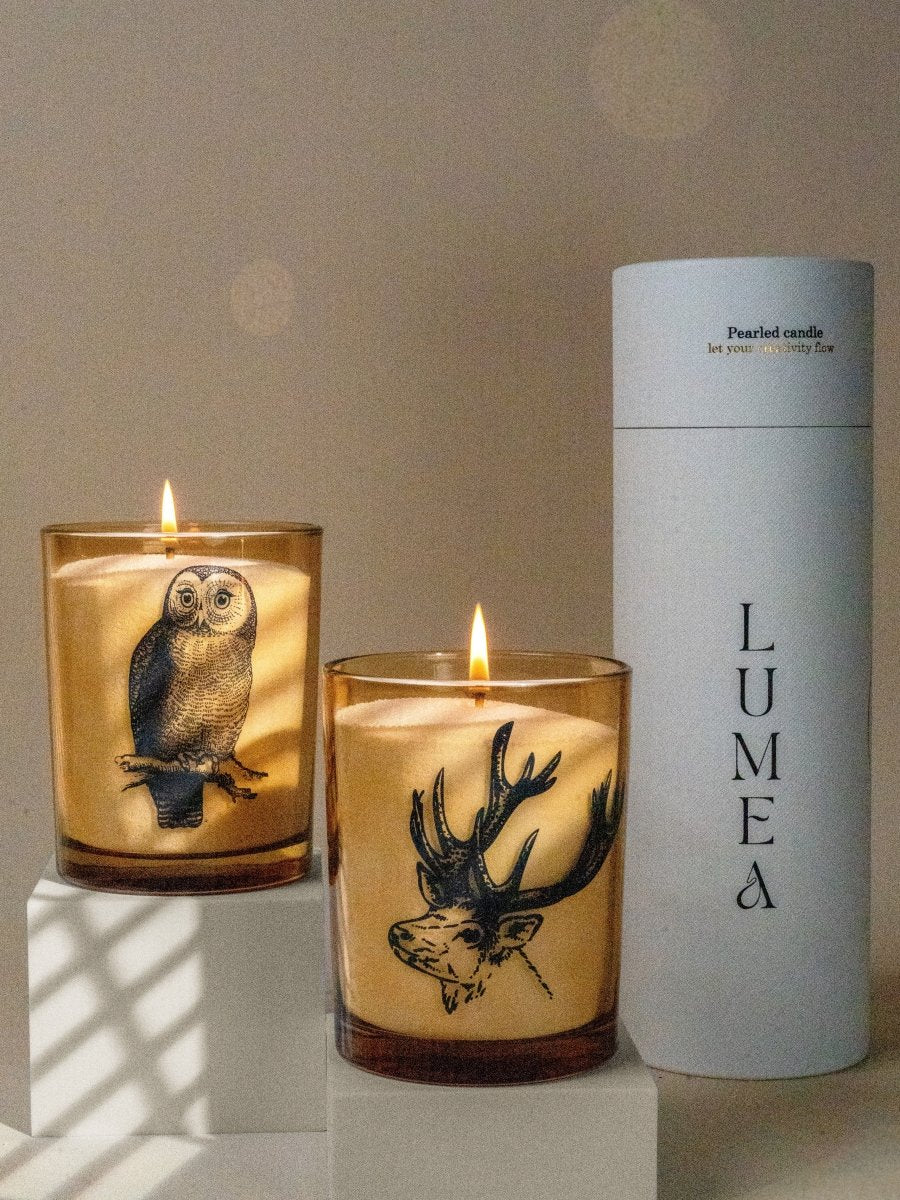 Bougies perlées Lumea allumées dans des pots en verre ambré illustrés d’un hibou et d’un cerf – décoration chaleureuse et nature, idéale pour une ambiance hivernale ou boisée.