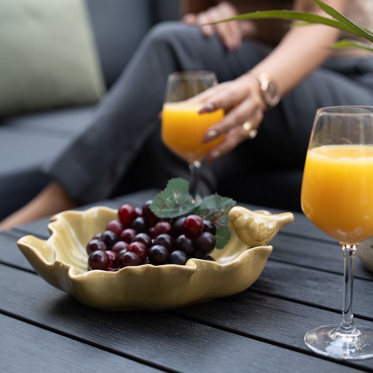 Coupelle en céramique jaune en forme de feuille avec petit oiseau décoratif, utilisée pour présenter du raisin lors d’un brunch en terrasse ; parfaite comme idée cadeau déco ou accessoire de table convivial.