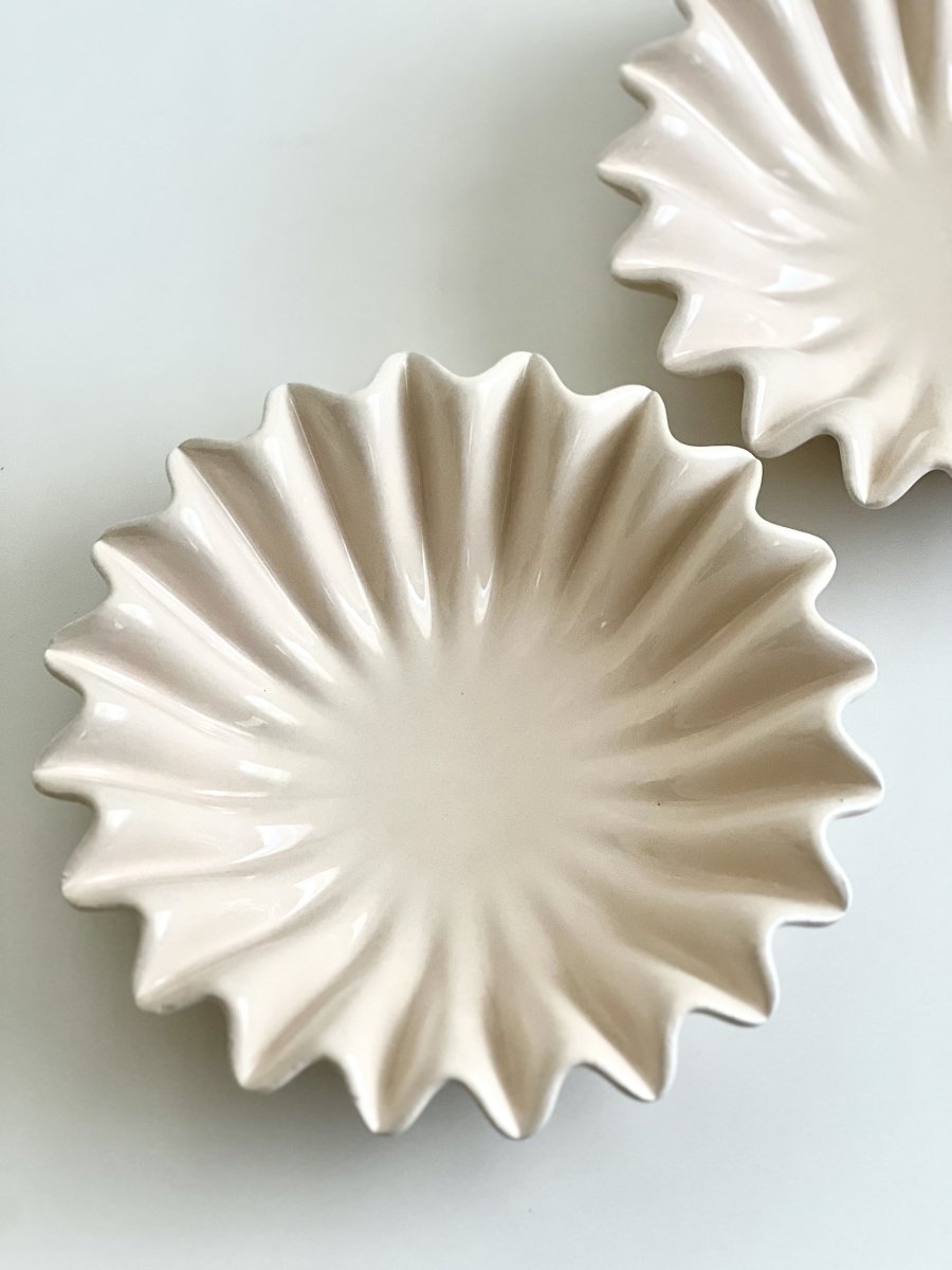 Coupelles décoratives en céramique beige à forme sculpturale ondulée, idéales comme support de bougie perlée ou objet de décoration intérieur moderne.