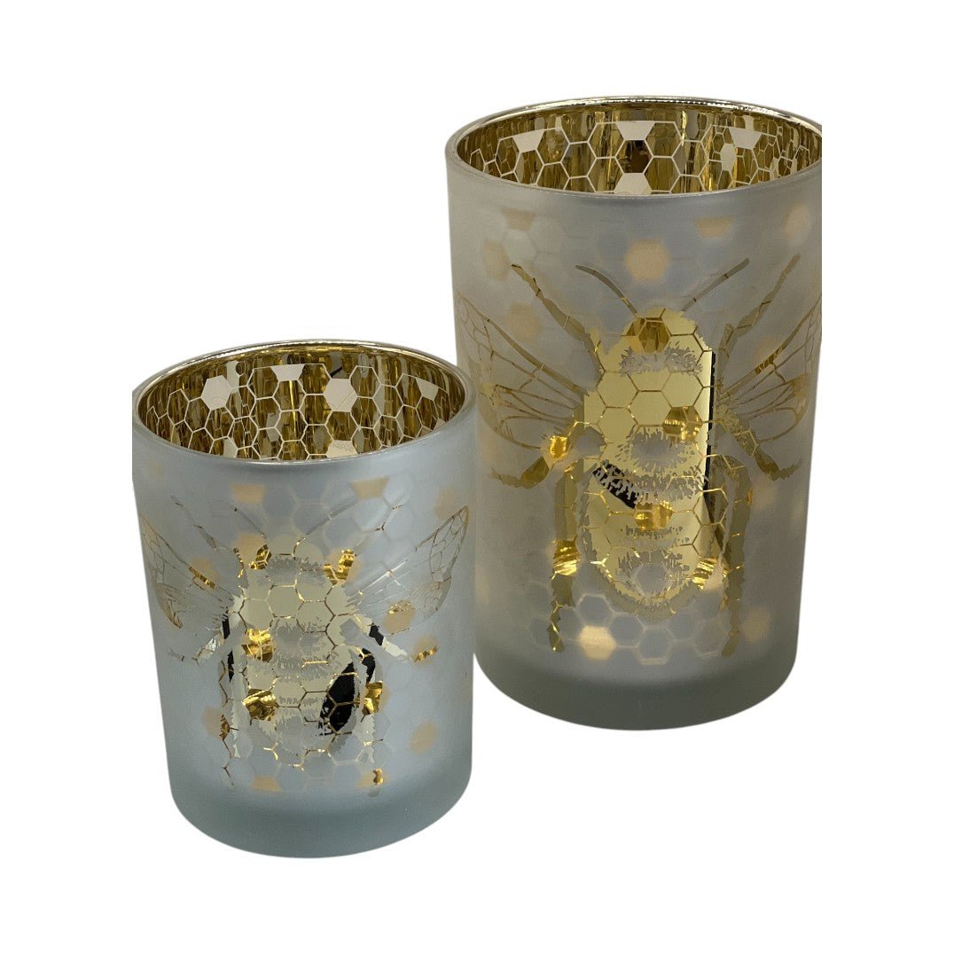 Duo de photophores en verre givré blanc avec motifs d’abeilles dorées et alvéoles en nid d’abeille, intérieur doré brillant, ambiance nature et chic.