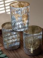 Trio de photophores argentés avec reflets givrés et motifs dorés d’arbres et de feuillages – objets déco pour créer une ambiance cosy, hivernale et élégante.