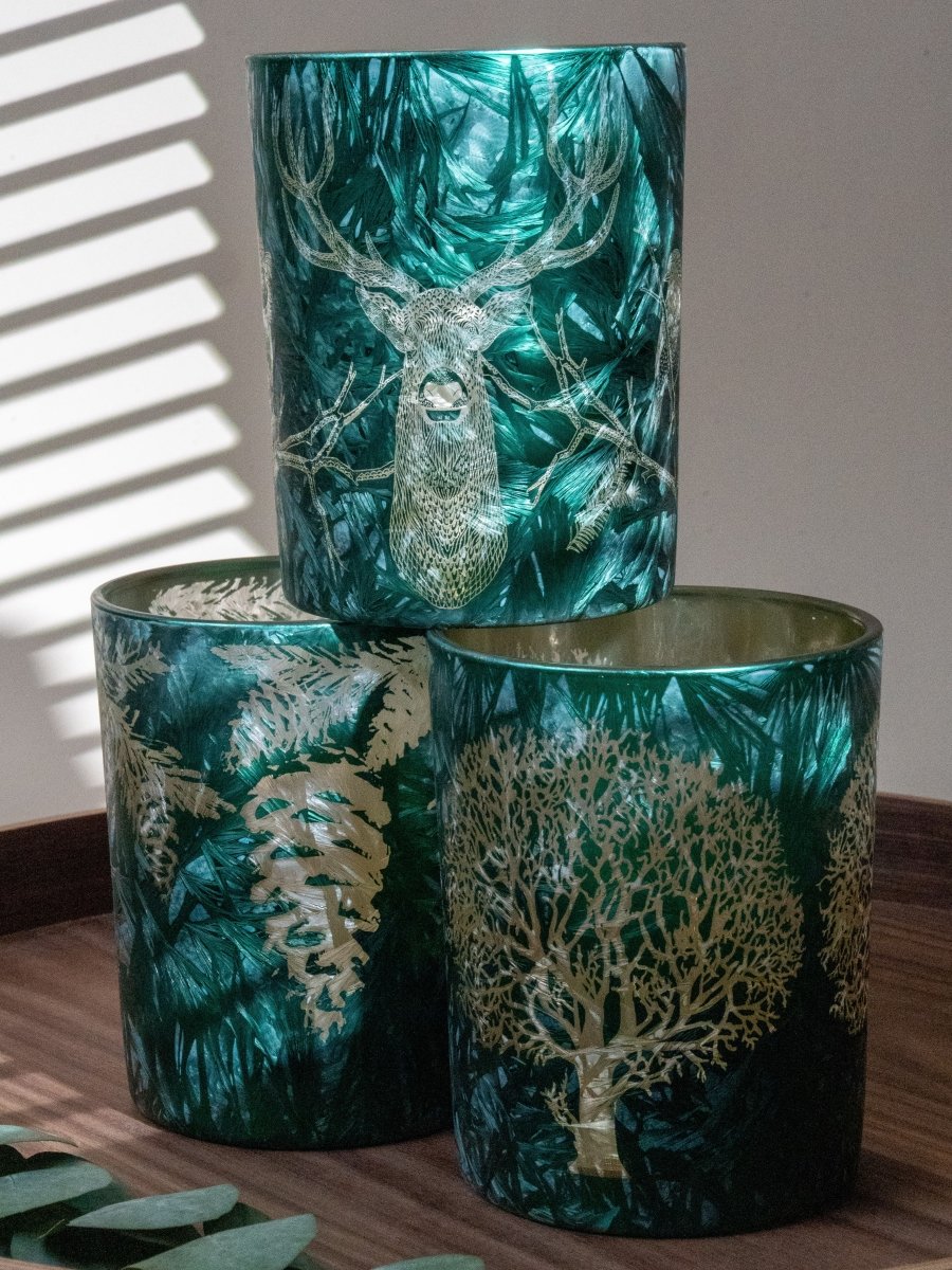 Ensemble de photophores vert émeraude avec motifs dorés de cerf, arbre et feuillages – accessoires décoratifs pour une ambiance chaleureuse, nature et festive.